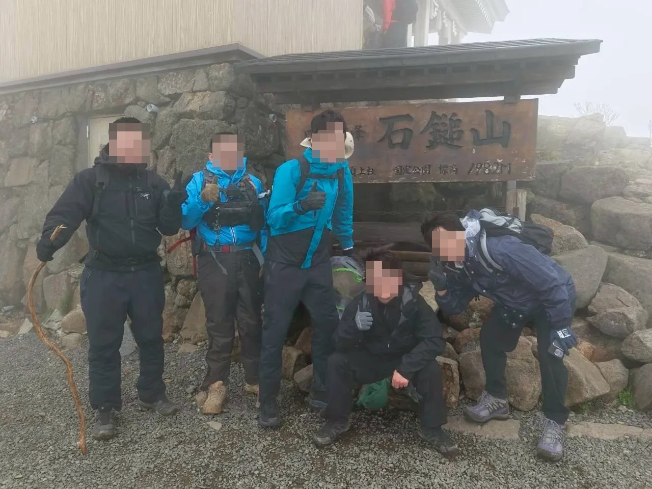 石鎚山山頂の看板前での集合写真。5人全員が笑顔で記念撮影。